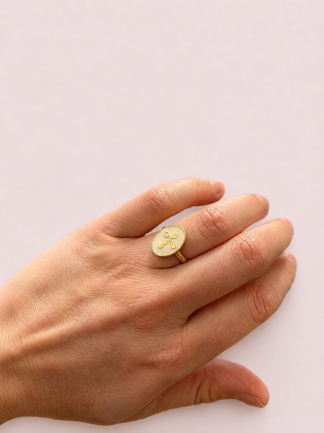 Bague Croix Nacrée portée sur les doigts dans un style raffiné et lumineux