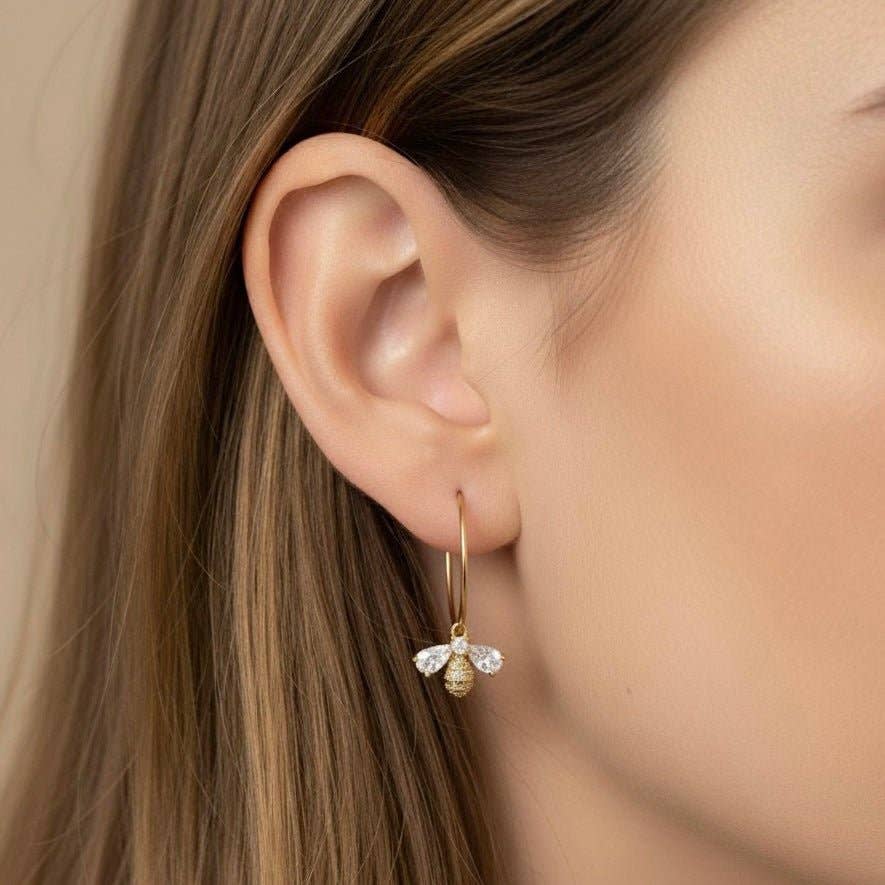 Boucles d’oreilles Abeille Divine dorées portées par mannequin – Bijoux Croix