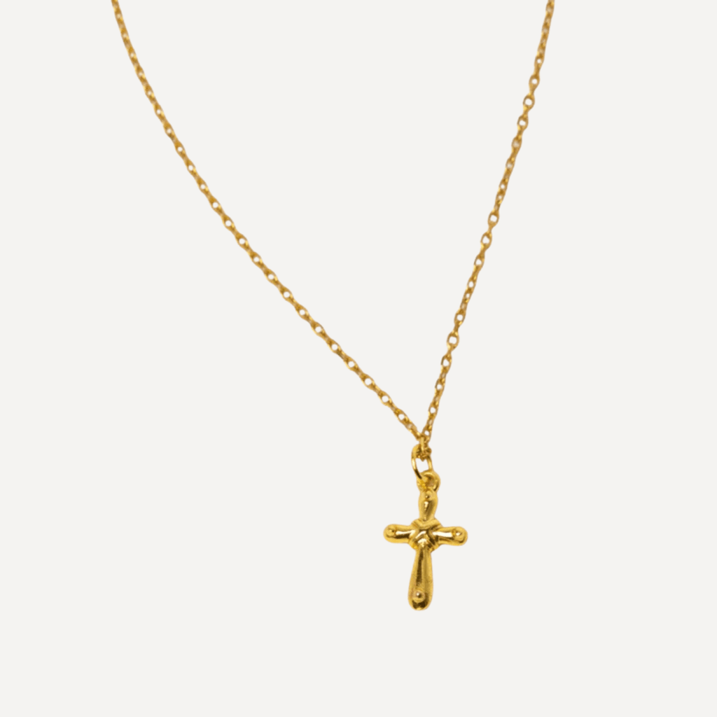 Gros plan du collier Croix Déborah en plaqué or sur sa chaîne 
