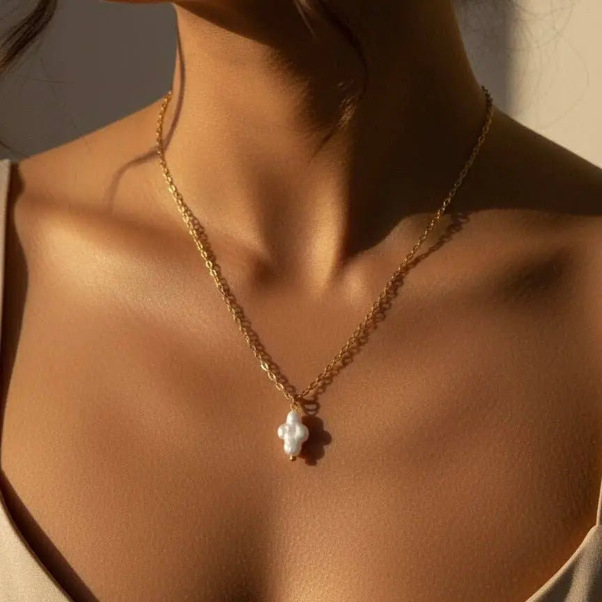 Collier croix femme porté orné d’une perle de Keshi
