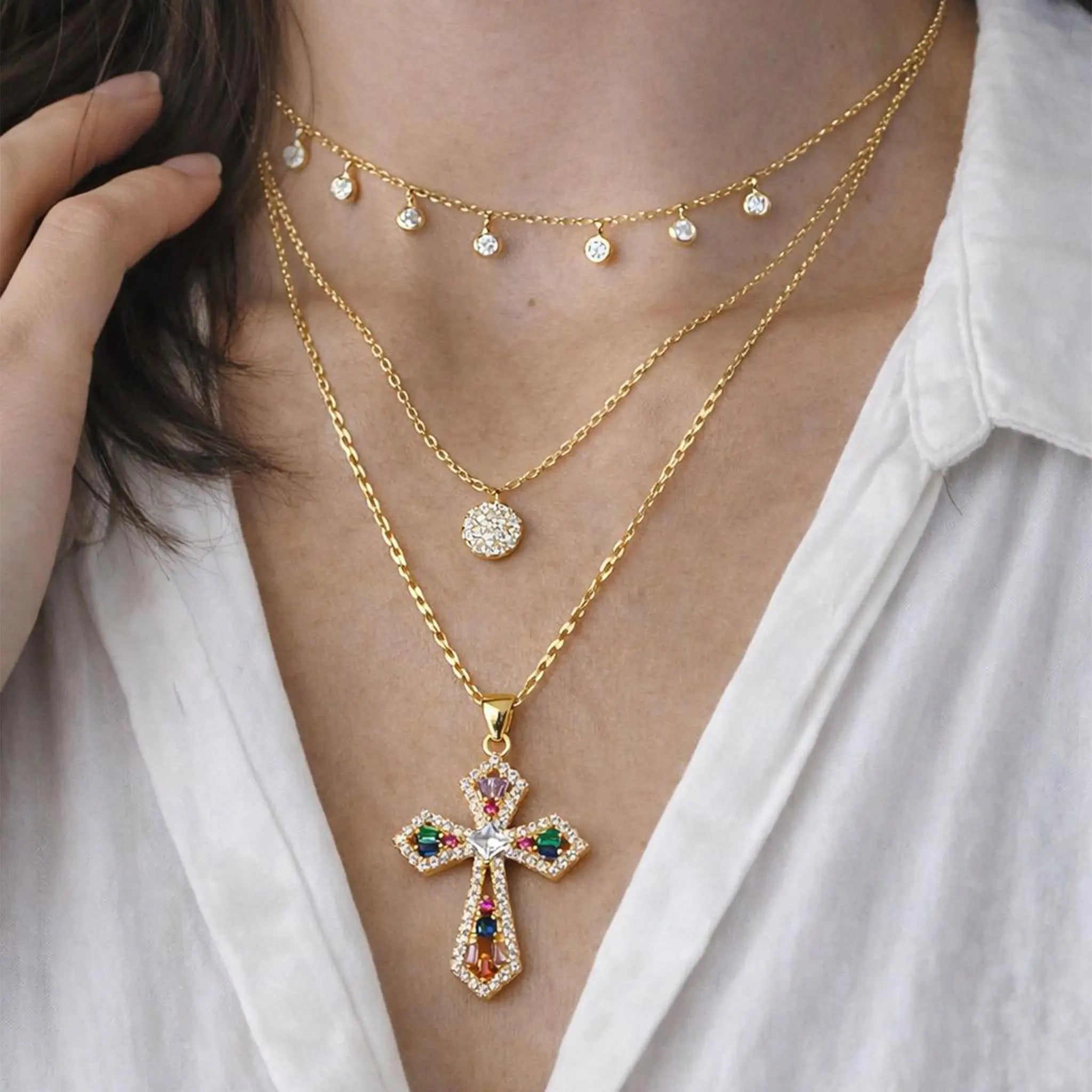 Collier Croix Templière porté avec plusieurs bijoux avec une chemise blanche