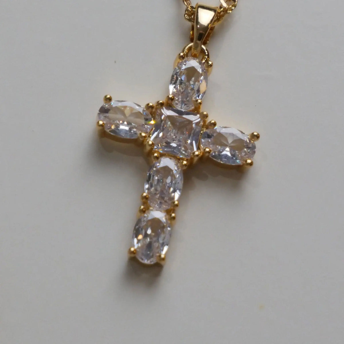 Gros plan sur le pendentif croix brillant et ses détails lumineux